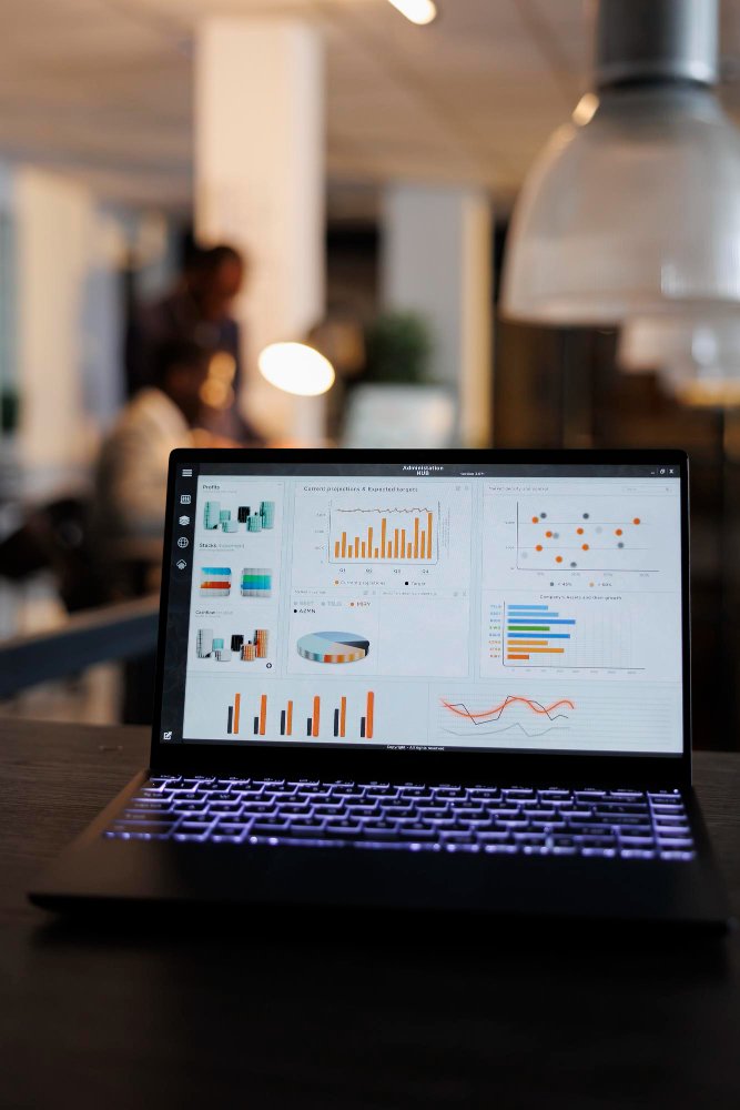 Laptop displaying analytical graphs and charts in a modern office setting, illustrating data analysis for Google Map SEO strategies.