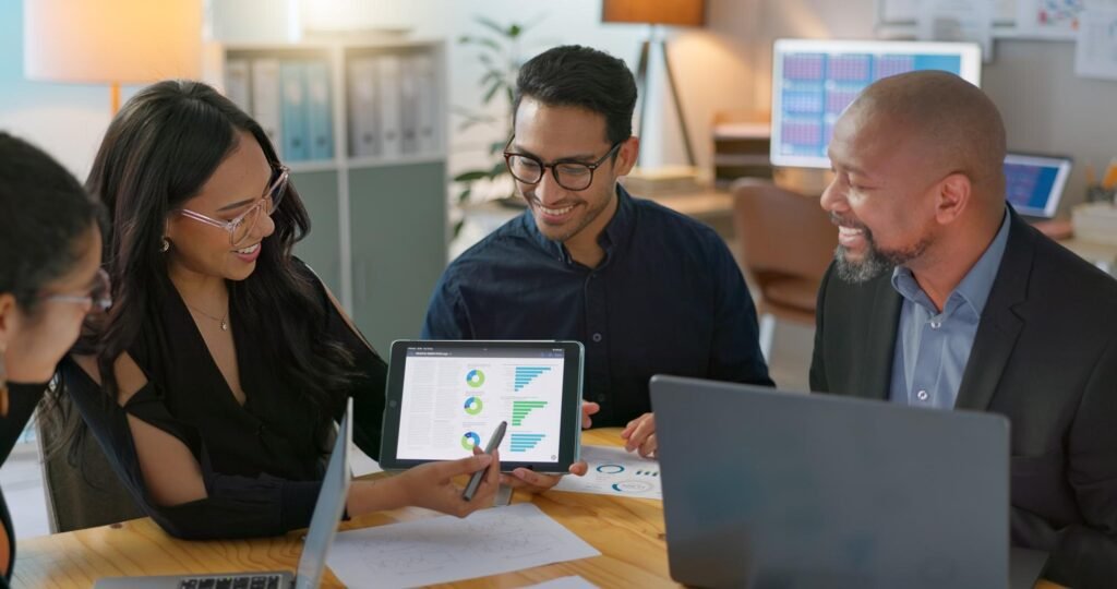 Team collaborating on digital marketing strategies, reviewing data visualisations on a tablet, enhancing local SEO and customer engagement for Google Business Profiles.