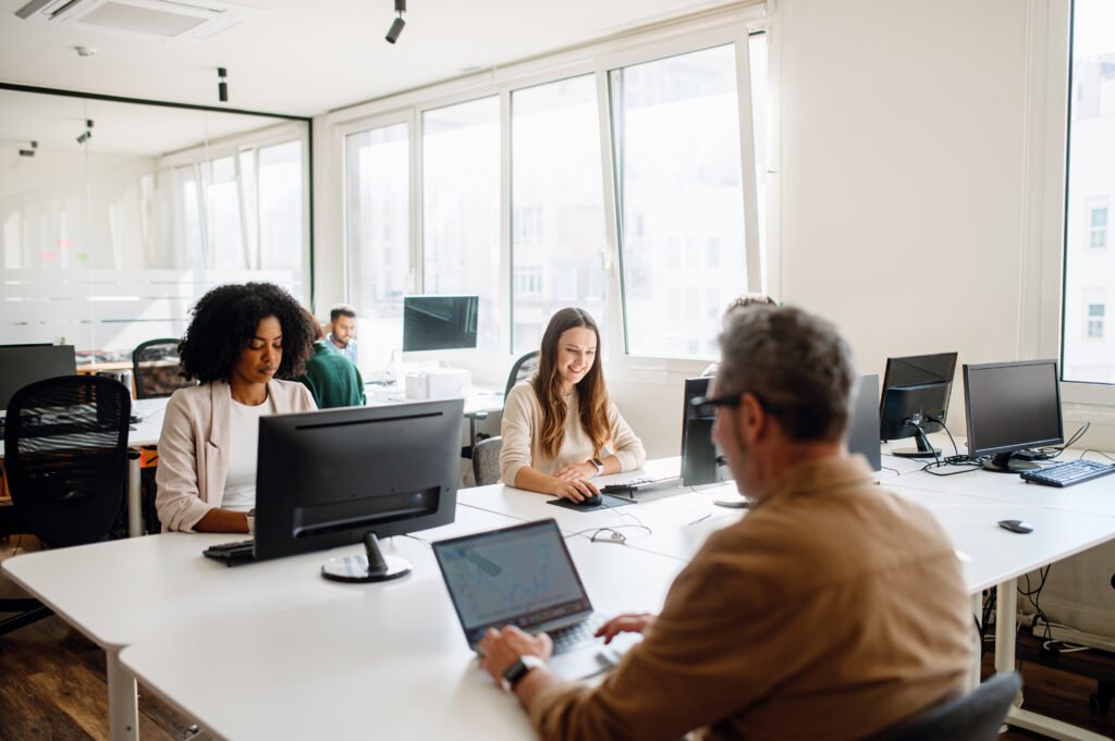 Office environment with diverse professionals engaged in work on computers, illustrating collaboration and productivity for enhancing Google Business Profiles and local SEO strategies.