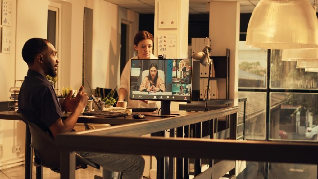 Professional setting with a man and woman discussing video content strategies via video call on a computer, highlighting collaboration for enhancing Google Business Profiles.